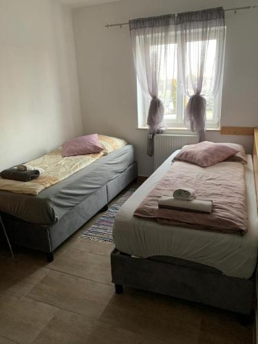 two twin beds in a bedroom with a window at ZV-Scholtz Gästehaus Eisenfelden in Winhöring