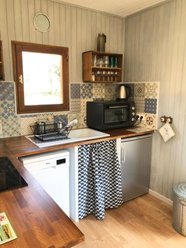 a kitchen with a counter top with a microwave at Chalet Sérénité in Moux-en-Morvan