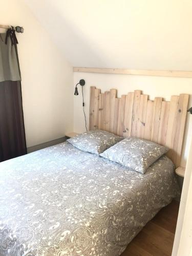 a bedroom with a bed with a wooden headboard at Chalet Sérénité in Moux-en-Morvan