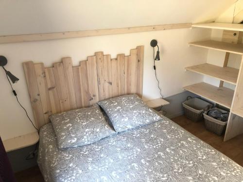 a bedroom with a bed with a wooden headboard at Chalet Sérénité in Moux-en-Morvan