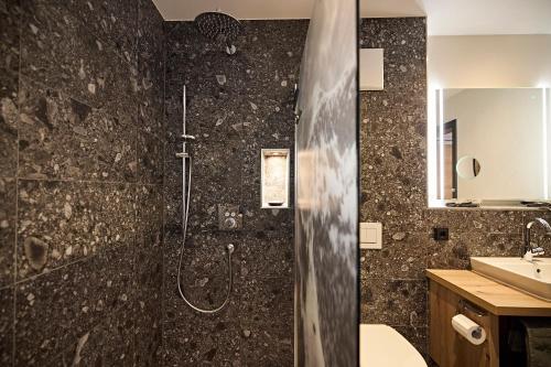 a bathroom with a shower and a sink at Siplinger Suites - Ferienwohnungen - Sauna und Fitness in Balderschwang