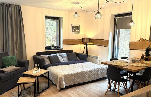 a living room with a bed and a table at Apartmán Mlýn Herlíkovice 205 in Vrchlabí