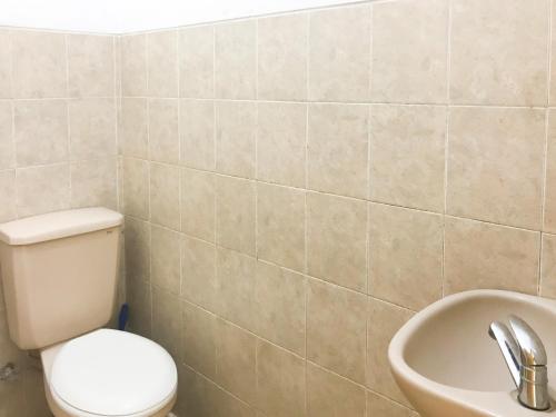 a bathroom with a toilet and a sink at Villa Bunga Guest House RedPartner in Malang