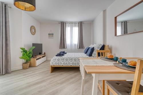- une chambre avec un lit et une table à manger dans l'établissement Logement Jules, Évry-Courcouronnes