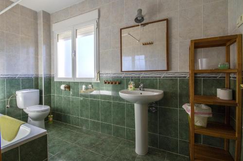 une salle de bain avec un lavabo, des toilettes et un miroir dans l'établissement AT Las Viñuelas 17, à Burgohondo