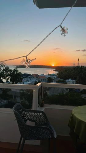 a chair sitting on a balcony with a sunset at Bluebay 360 seaview in Blue Bay