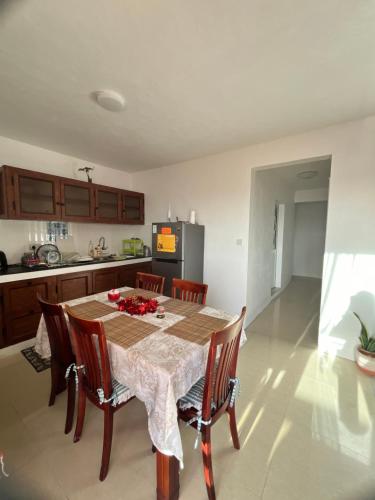 a kitchen with a table with chairs and a refrigerator at Bluebay 360 seaview in Blue Bay