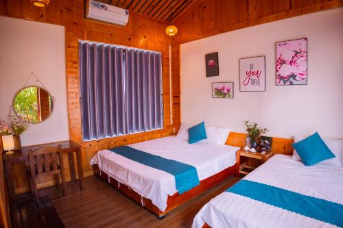 a bedroom with two beds and a window at Rosa Garden in Ninh Binh