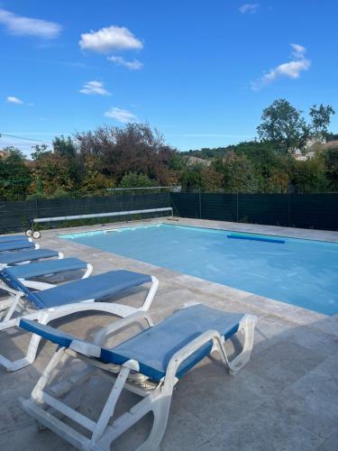 - un groupe de chaises longues à côté de la piscine dans l'établissement Gite de Leoli Ardèche, à Saint-Remèze