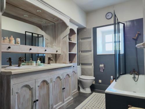 une salle de bain avec un lavabo, des toilettes et une baignoire dans l'établissement Le Clos Lagrange-10 pers-Piscine privée, à Varaignes