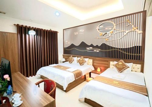 a hotel room with two beds and a dining table at TamCoc Golden Shine Homestay in Ninh Binh