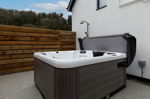 a bath tub sitting on the side of a building at The Little House in Oxwich in Oxwich