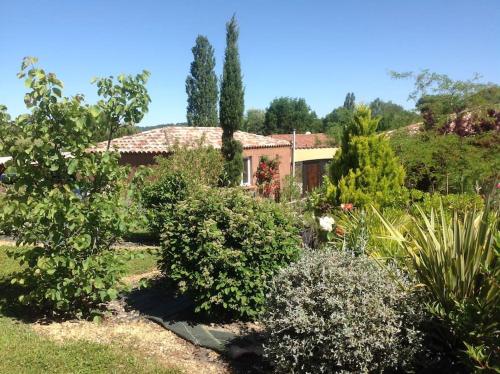 un jardin avec une maison en arrière-plan dans l'établissement Gers habitation, à Montégut