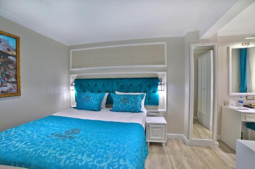 a bedroom with a blue bed and a bathroom at Glamour Hotel Istanbul Sirkeci in Istanbul