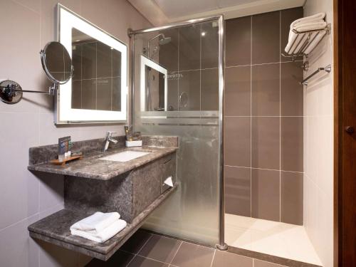 a bathroom with a sink and a shower at Novotel Jazan in Jazan