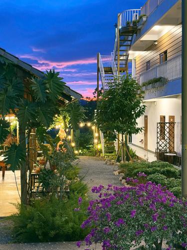a courtyard of a building with purple flowers at Dứa Homestay in Bao Loc