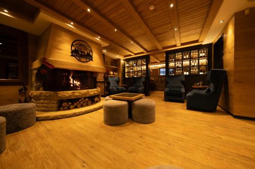 a lobby with a fireplace and chairs and a table at Hotel Petit Lacreu in Salardú