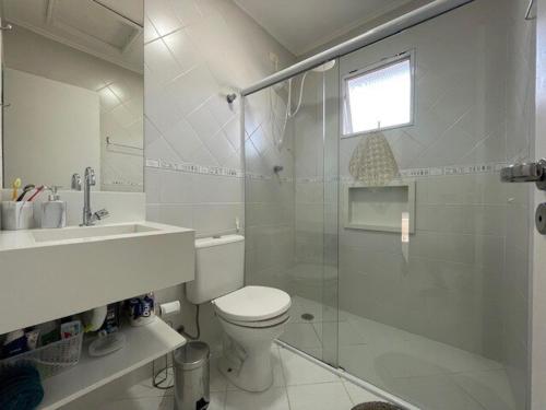 a bathroom with a shower and a toilet and a sink at Beautiful Casa em Riviera in Bertioga