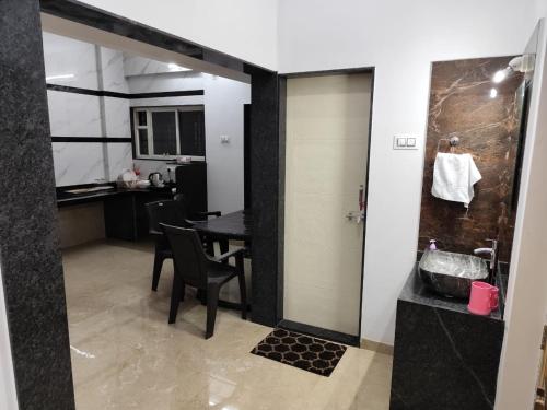a bathroom with a table and a sink in a room at Guruprasad Home Stay in Kolhapur