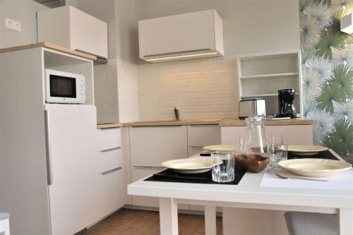 - une cuisine avec une table et des bols dans l'établissement Appartement 2 pièces - Gruissan GN460-010, à Gruissan