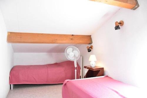 - une chambre avec un lit rose et un ventilateur dans l'établissement Maison 2 pièces mezzanine - Gruissan Ayguades AY050-137, à Vires