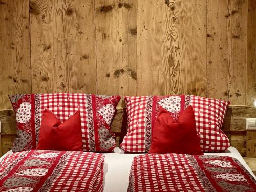 a bed with red and white pillows on it at Biobetrieb Lippenhof in Breitnau