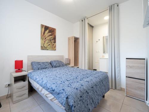 une chambre avec un lit bleu et un miroir dans l'établissement La Dune N 71 - Villa 4P6, à Sérignan