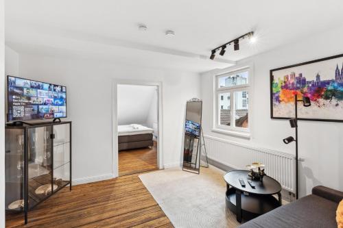 a living room with a couch and a tv at Residenz im historischen Zentrum - Aalen Apartments & Suites in Aalen