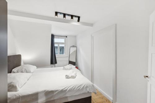 a white bedroom with a bed and a mirror at Residenz im historischen Zentrum - Aalen Apartments & Suites in Aalen