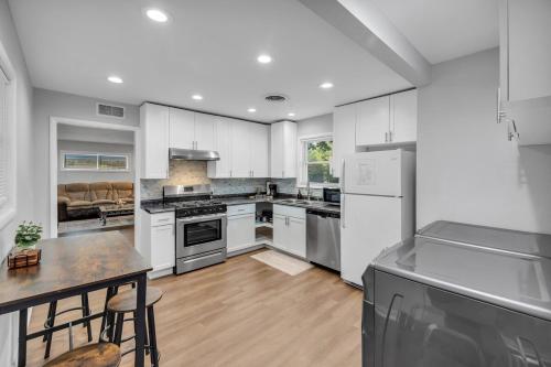 a large kitchen with white cabinets and a table at EXPO HOME just minutes from downtown Tulsa in Tulsa