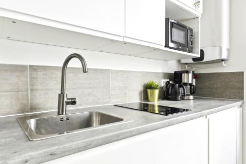 une cuisine avec un évier et un micro-ondes dans l'établissement Luxury suite near Eiffel Tower, à Paris
