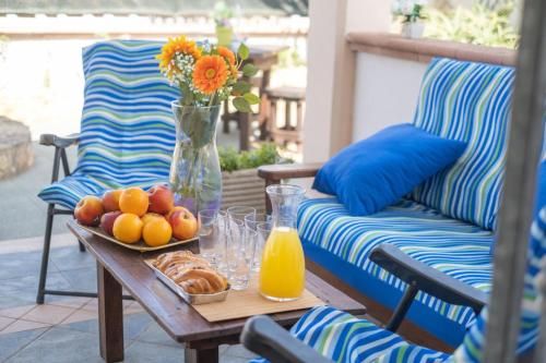 a table with a plate of fruit and a vase of flowers at White Sand Private Villa Near The Sea, Wifi in Torre Squillace