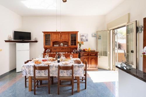 a dining room with a table and a kitchen at White Sand Private Villa Near The Sea, Wifi in Torre Squillace