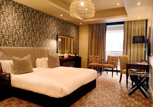 a hotel room with a large bed and a desk and a desk at Royal Palm Hotel in Durban