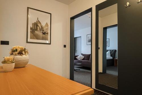 a living room with a table and a mirror at Hotel Alekto in Freiberg