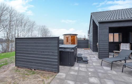a patio with two chairs and a black building at Cozy Home In Jesendorf With Sauna in Jesendorf