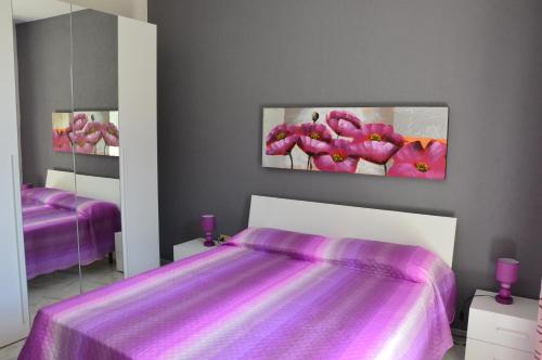 マルサラにあるHoliday home Villetta Le Duneのベッドルーム(紫色のベッド1台、鏡2つ付)