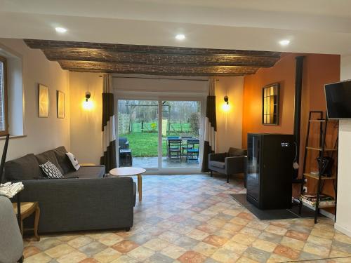 a living room with a couch and a tv at Chambre d'Hotes La Chaiserie in Romeries