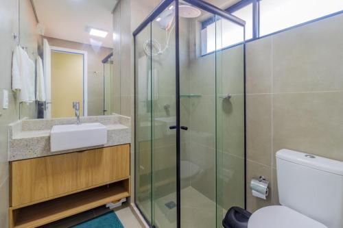 a bathroom with a glass shower and a sink at Rooftop Tamandaré - apto 106 in Tamandaré