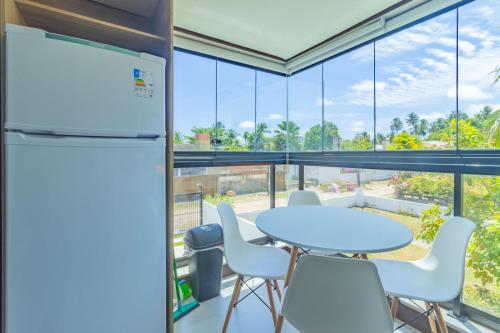 a kitchen with a table and chairs and large windows at Rooftop Tamandaré - apto 106 in Tamandaré