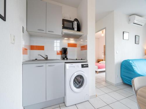 une cuisine avec une machine à laver dans une pièce dans l'établissement Cap Camargue A N 14 - 2P4, au Grau-du-Roi