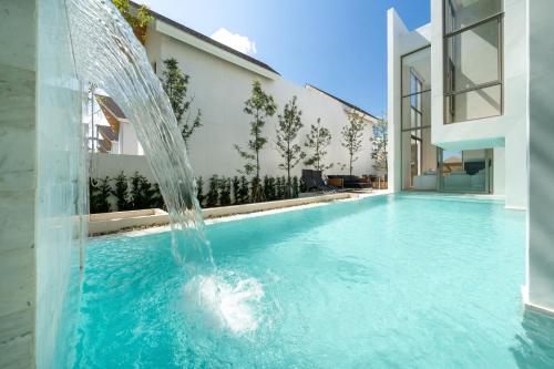 a water fountain in a swimming pool next to a building at Exclusive New Build - Designer 3BR Pool Villa in Prestigious LuxPride 4 L7 Residence in Bang Tao Beach