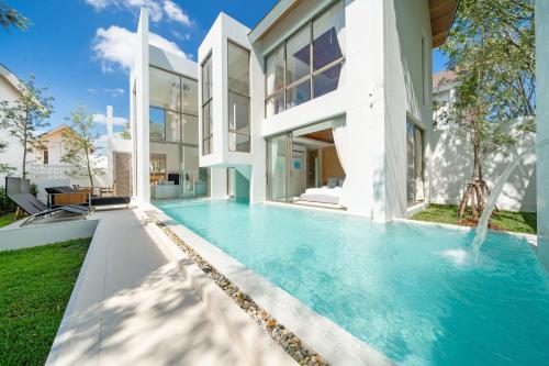 a swimming pool in the backyard of a house at Exclusive New Build - Designer 3BR Pool Villa in Prestigious LuxPride 4 L7 Residence in Bang Tao Beach