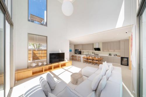 a living room with a white couch and a kitchen at Exclusive New Build - Designer 3BR Pool Villa in Prestigious LuxPride 4 L7 Residence in Bang Tao Beach