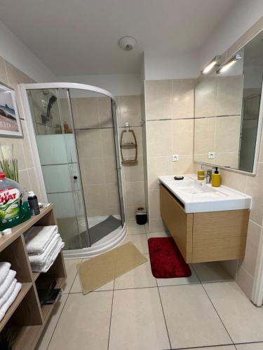 La salle de bains est pourvue d'une douche et d'un lavabo blanc. dans l'établissement Panoramic view, perfect between sea and mountain, à Mandelieu-la-Napoule