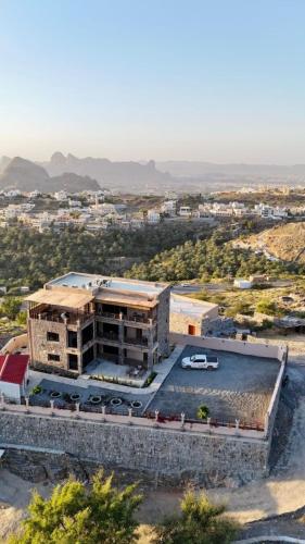 an overhead view of a building with a parking lot at Roghan Hospitality Inn in Al Ḩamrāʼ
