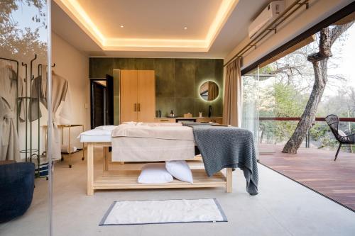 a bedroom with a bed and a sliding glass door at Serondella Safari Lodge in Thornybush Game Reserve