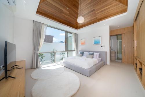 a bedroom with a bed and a large window at Exclusive New Build - Designer 3BR Pool Villa in Prestigious LuxPride 4 L7 Residence in Bang Tao Beach