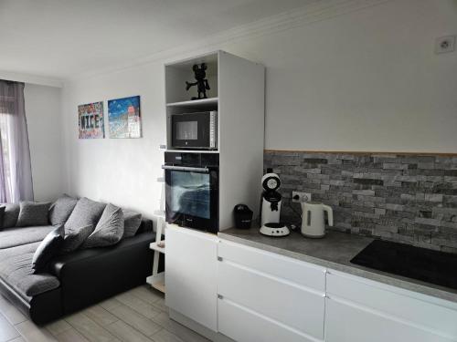 un salon avec un canapé et une cuisine dans l'établissement L'escapade vers le bien-être, à Nice