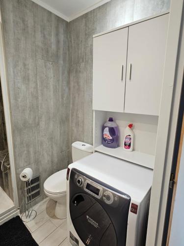 une petite salle de bains avec un lave-vaisselle au-dessus d'un réfrigérateur dans l'établissement L'escapade vers le bien-être, à Nice